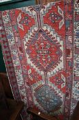 A Persian style runner with interlocking lozenges on a predominately red and blue ground 3 meters