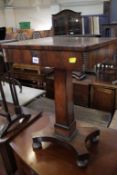An early Victorian rosewood sewing table with sliding top on square tapering column, concave base,