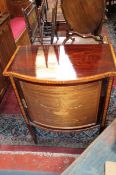 A bow front cabinet with decorative marquetry to the door.