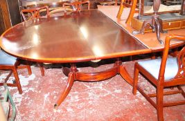 A large reproduction dining table on four column support joined by circular stretcher and splayed