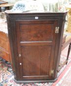 An 18th Century oak panelled corner cupboard enclosing shelves 116cm high, 75cm wide