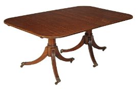 A 19th century mahogany extending dining table with extra leaves raised on two swept pedestals