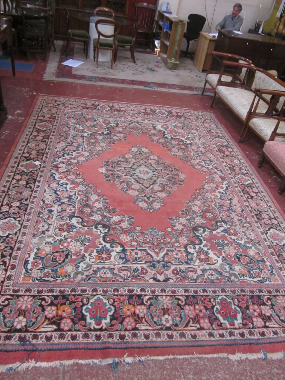 A large Persian carpet with central medallion on a floral pink ground; 280 x 390cm