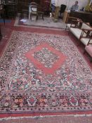 A large Persian carpet with central medallion on a floral pink ground; 280 x 390cm