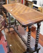 A Victorian walnut games table with chequer board top on bobbin turned supports.