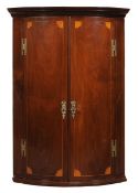 A George III mahogany corner cabinet, circa 1770, the double doors enclosing four shelves and three