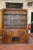 A dresser made from reclaimed elm with enclosed plate rack over central drawers flanked by