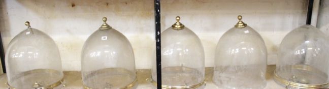 * A group of five hanging glass domes with brass fittings