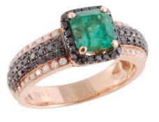 An emerald and diamond ring, the central rectangular cut emerald in a four claw setting within a