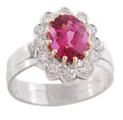 A rubellite and diamond ring, the oval shaped rubellite claw set within a surround of brilliant