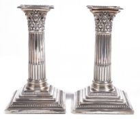 A pair of Edwardian silver dwarf corinthian candlesticks, maker  A pair of Edwardian silver dwarf