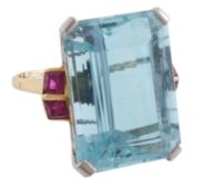 An aquamarine and ruby ring, the rectangular step cut aquamarine, estimated to weigh 26 carats, in