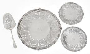 A matched silver dessert serving plate, two smaller plates and a cake slice en suite by Walker &