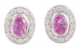 A pair of pink sapphire and diamond earrings, the oval cut pink sapphire in a collet setting within