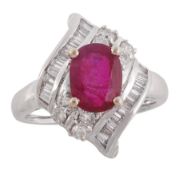 A ruby and diamond cluster ring, the oval cut ruby in a four claw setting above a shaped brilliant