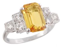 A yellow sapphire and diamond ring, the rectangular step cut yellow sapphire in a four claw