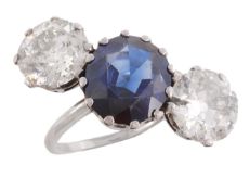 A diamond and sapphire three stone ring, the central circular cut sapphire, weighing 6.90 carats,