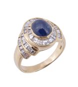 A sapphire and diamond dress ring,  the oval cabochon sapphire within a surround of channel set