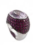 A kunzite and ruby dress ring, the oval cut kunzite within a pave set ruby setting, stamped Ô18kt`,