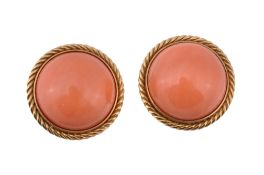 A pair of coral ear clips, the ciruclar cabochon coral (Corallium Rubrum) within a ropetwist