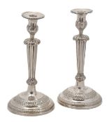 A pair of Continental silver candlesticks, four indistinct marks including a crowned G, with beaded