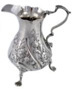 An early George III silver baluster cream jug, maker`s mark illegible, London 1765, with a leaf-