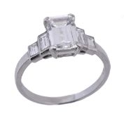 A diamond ring, the central emerald cut diamond in a four claw setting, weighing 1.41 carats, to