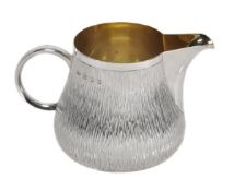 A silver cream jug by Gerald Benney, London 1988, stamped Gerald Benney London, with a polished rim