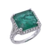 An 18 carat gold emerald and diamond ring, the square cut emerald in a four claw setting within a