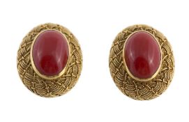 A coral set ring and ear clip suite, the ring with an oval cabochon coral (coralium rubrum) within