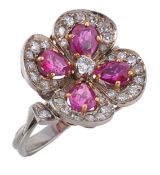 A ruby and diamond clover ring, the four leaf clover set with a central brilliant cut diamond, to