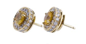 A pair of yellow sapphire and diamond cluster earstuds, the round cut yellow sapphires within a