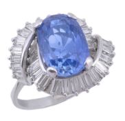A sapphire and diamond cluster ring, the central oval cut sapphire in a four claw setting, within a