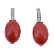 A pair of coral and diamond earrings, the oval cabochon coral panels surmounted with a vertical row