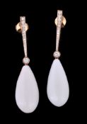 A pair of coral and diamond ear pendents, the polished coral drops suspended below a collet set