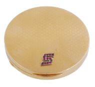 A ruby accented gold coloured compact, the circular compact with honeycomb style decoration and an