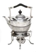 A silver tea kettle on stand by Goldsmiths & Silversmiths Co. Ltd., Sheffield 1919, with a