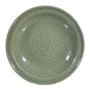 A Longquan celadon dish, Ming, moulded with a peony within bands of scrolling lotus and waves, two