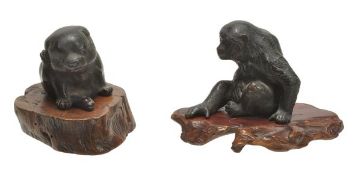 Two small Japanese bronze models of a monkey and a dog, both seated, the eyes inlaid with a red