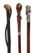 A carved and ebonised wood walking stick, possibly Irish, late 19th century, the grip modelled as