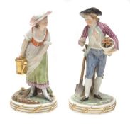 A pair of Royal Copenhagen models of a gardener and companion, circa 1900, modelled wearing