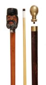 A carved and polychrome painted wood and white metal mounted malacca system walking stick, circa