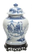 A Chinese porcelain blue and white lidded jar of baluster shape decorated with sages amid a