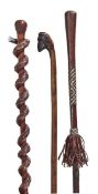 A carved and stained wood and white metal mounted walking stick, early 20th century, the knob grip
