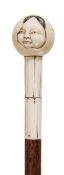 A carved ivory and stained hardwood mounted semi-erotic walking stick, early 20th century, possibly