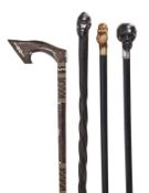 A carved and ebonised wood and white metal mounted ebony walking stick, late 19th century, the grip