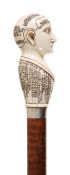 A Victorian sculpted ivory and later mounted stained hardwood walking stick, the ivory grip 19th
