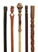 A carved and stained hardwood and ivory mounted walking stick, possibly north American, early 20th