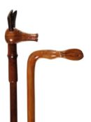 A carved and stained harwood walking stick, 20th century, the grip modelled as the stylised head of