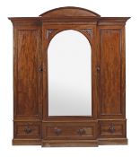 A Victorian mahogany breakfront wardrobe, circa 1860, with a moulded cornice, above a central mirror